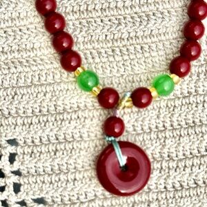 Red and green beaded bracelet with a 2" donut charm